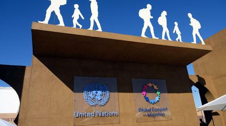 Die Logos der Vereinten Nationen und des Migrationspakts