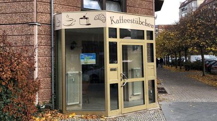 Vor dem Backshop stehen zwei Männer, sie essen und rauchen gleichzeitig und unterhalten sich über etwas gänzlich anderes als über Wunder.