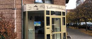 Vor dem Backshop stehen zwei Männer, sie essen und rauchen gleichzeitig und unterhalten sich über etwas gänzlich anderes als über Wunder.