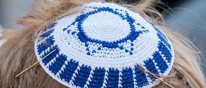 Mit einer Kippa als Kopfbedeckung geht ein Teilnehmer des Kippa-Walks zu einer Demonstration. (Archivbild)