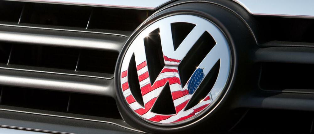 Die US-Fahne spiegelt sich in Logo und Kühlergrill eines Volkswagen-Fahrzeugs.
