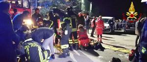 Rettungskräfte kümmern sich nach einer Massenpanik in einer Diskothek um Verletzte.