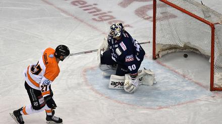 Ausgeguckt. Der Wolfsburger Cole Cassels schiebt den Puck an Eisbären-Torwart Kevin Poulin vorbei.