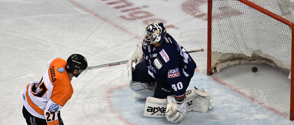 Ausgeguckt. Der Wolfsburger Cole Cassels schiebt den Puck an Eisbären-Torwart Kevin Poulin vorbei.