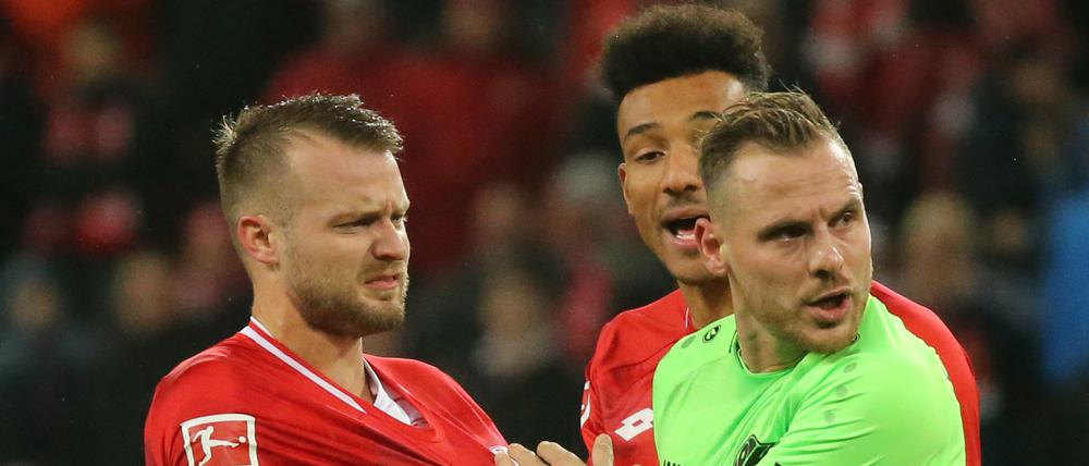 Nichts als Ärger um den Videobeweis: Der Mainzer Daniel Brosinskiwird nach dem 1.1 per Elfmeter von Hannovers Marvin Bakalorz bedrängt.