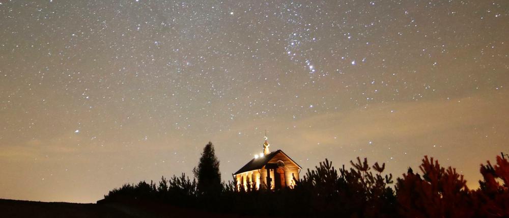 Sternschnuppen sind am nächtlichen Himmel zu sehen. Die Meteoriten gehören zu den Geminiden die alljährlich am Nachthimmel zu beobachten sind.