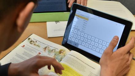 Ein Schüler arbeitet in seinem Klassenzimmer am Tablet. 