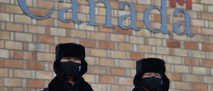 Zwei chinesische Polizisten sichern nach der Festnahme einer Chinesin in Vancouver die kanadische Botschaft in Peking.