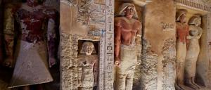 Blick in die jetzt geöffnete Grabkammer mit Statuen und farbigen Wandreliefs.