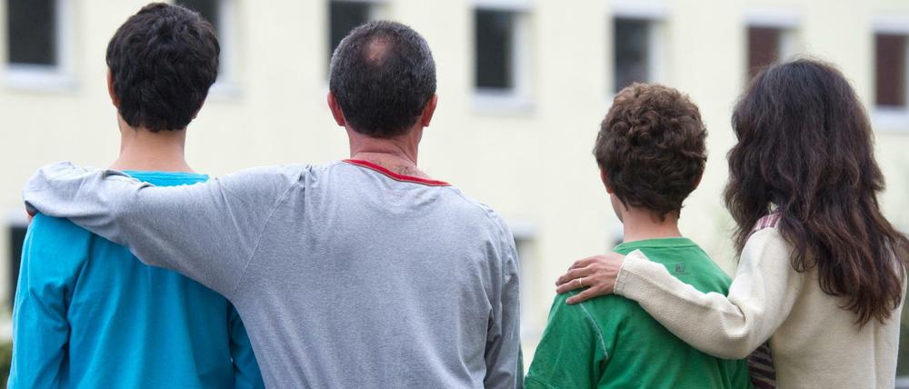 Eine syrische Familie sitzt vor einem Asylwohnheim des Landes Brandenburg. 
