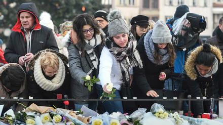 Passanten gedenken in Straßburg der fünf Toten des Terrorattentats. 