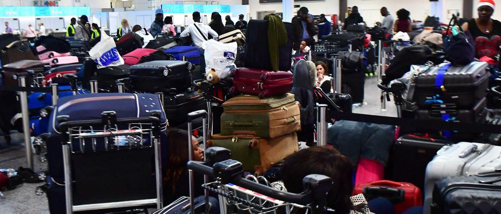 Passagiere und ihr Gepäck warten auf dem Flughafen Gatwick auf ihren Abflug.