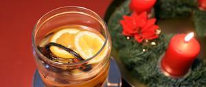 Ein Glas mit selbstgemachtem Raumduft steht neben einem Adventskranz.