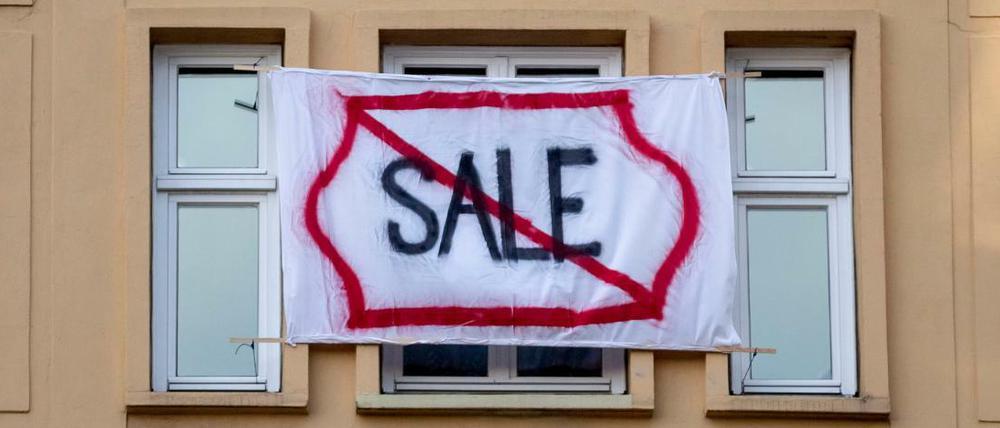 Ein Plakat gegen den Verkauf von Mietwohnungen an die Deutsche Wohnen in der Karl-Marx-Allee.
