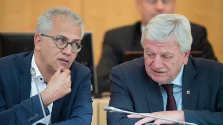 Wirtschaftsminister Tarek Al-Wazir (Grüne,l) und Hessens Ministerpräsident Volker Bouffier (CDU) unterhalten sich im Landtag.