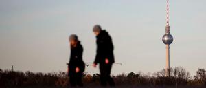 Spaziergänger gehen auf dem Tempelhofer Feld vor dem Berliner Fernsehturm. Statt Schnee ist es in Deutschland grau und trüb.