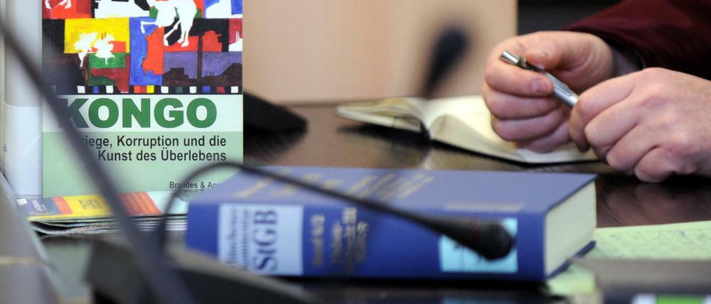 In einem Gerichtssaal im Oberlandesgericht liegt neben Prozessunterlagen und einem Gesetzbuch ein Buch über Kriminalität im Kongo. 