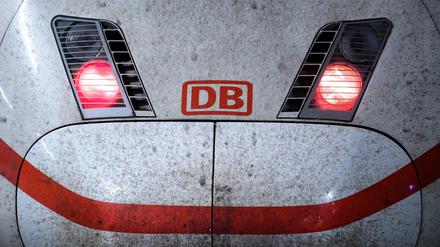 Rote Rücklichter leuchten am Triebwagen eines ICE-Zuges der Deutschen Bahn.