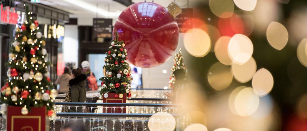 Kunden gehen durch ein weihnachtlich geschmücktes Einkaufszentrum in Berlin-Mitte.