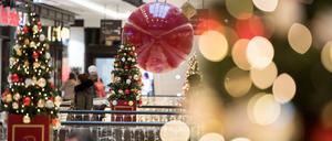 Kunden gehen durch ein weihnachtlich geschmücktes Einkaufszentrum in Berlin-Mitte.