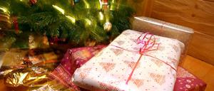 Weihnachtsgeschenke liegen unter einem geschmücktem Christbaum.