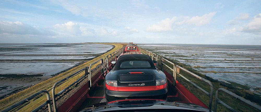 Ein Autozug fährt über den Hindenburgdamm in Richtung Sylt.