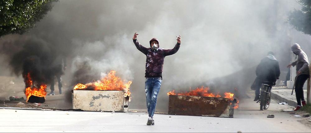 Ein Demonstrant vor brennenden Barrikaden im tunesischen Kasserine.