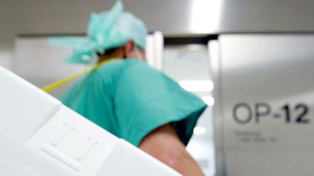 Ein Styropor-Behälter zum Transport von zur Transplantation vorgesehenen Organen wird am Eingang eines OP-Saales vorbei getragen.