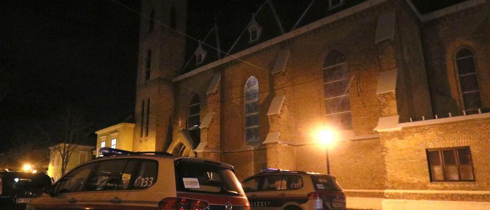 Polizeiautos stehen vor der überfallenen Kirche bei Wien