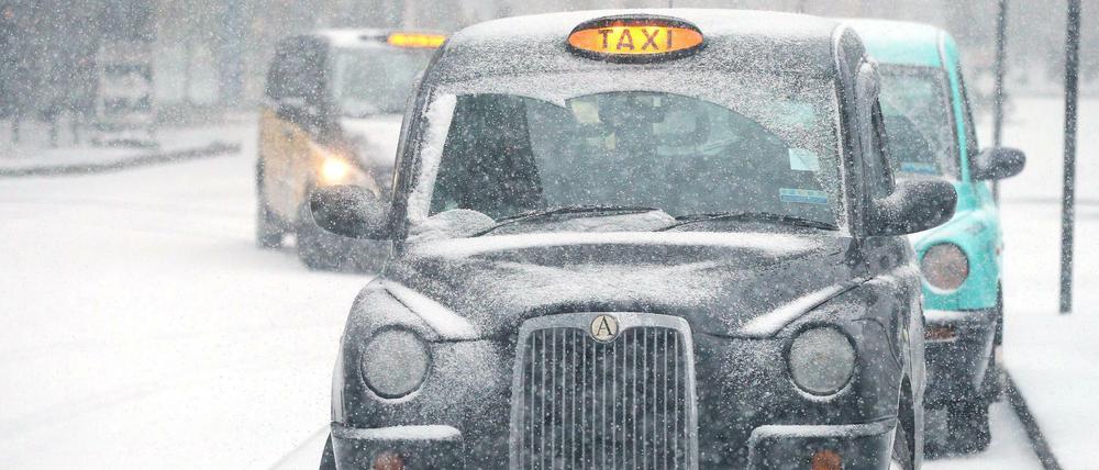 Ein Taxi fährt vergangenen Februar auf einer schneebedeckten Straße in London.