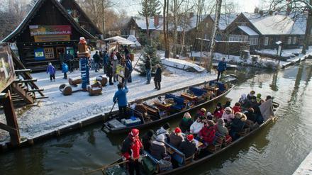 Im winterlichen Spreewalddorf Lehde (Brandenburg) gelangen Besucher mit einem Kahn zum Freilandmuseum.