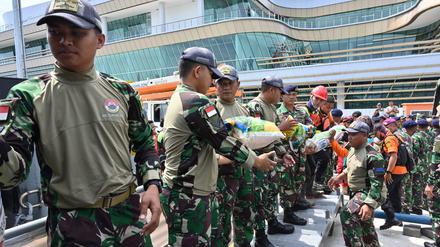 Indonesische Marinesoldaten und Rettungshelfer laden am 28. Dezember Hilfsgüter auf ein Schiff.