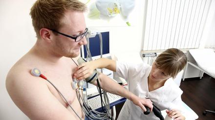 Arztpraxis. Belastungs-EKG Untersuchung zur Messung der Herzfunktionen, bei einem Patienten, auf einem Cardiogerät. Arztpraxis Medizin