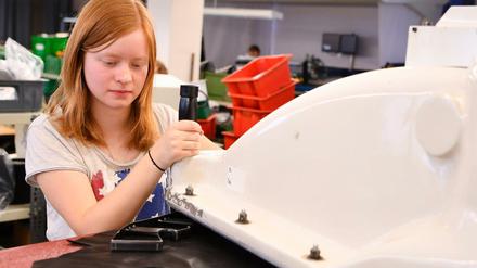 Die großen Maschinen in einer Schuhfabrik zu bedienen, ist für Azubis oft schwere Knochenarbeit.