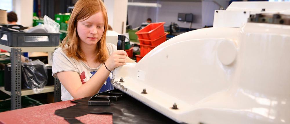 Die großen Maschinen in einer Schuhfabrik zu bedienen, ist für Azubis oft schwere Knochenarbeit.