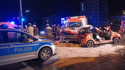 Fünf Verletzte: Feuerwehrleute stehen neben einem Pkw, der zuvor mit einem Rettungswagen und Polizeiauto zusammengestoßen war. 