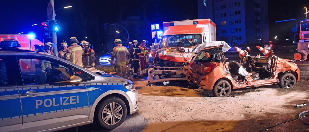 Fünf Verletzte: Feuerwehrleute stehen neben einem Pkw, der zuvor mit einem Rettungswagen und Polizeiauto zusammengestoßen war.