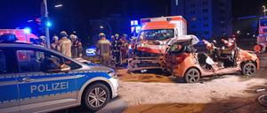 Fünf Verletzte: Feuerwehrleute stehen neben einem Pkw, der zuvor mit einem Rettungswagen und Polizeiauto zusammengestoßen war. 
