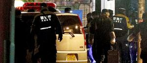 Polizisten inspizieren ein Auto in Tokio, nachdem es mehrere Fußgänger gerammt hat.