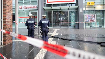  Polizisten laufen hinter Absperrband auf dem Berliner Platz in Bottrop. 