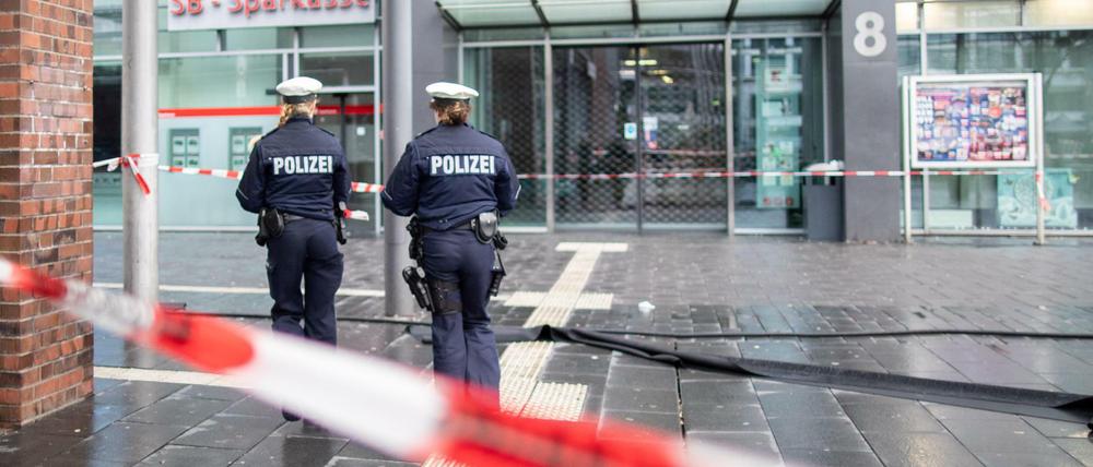  Polizisten laufen hinter Absperrband auf dem Berliner Platz in Bottrop. 