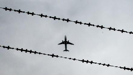 Ein Flugzeug ist hinter Stacheldraht zu sehen