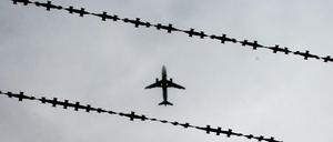 Ein Flugzeug ist hinter Stacheldraht zu sehen