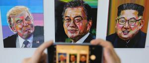 Ein Besucher fotografiert in einer Ausstellung in Seoul Bilder von US-Präsident Donald Trump, den südkoreanischen Präsidenten Moon Jae In und dem nordkoreanischen Führer Kim Jong Un.