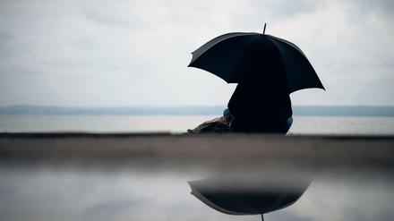 Bei dem Wetter lieber sinnieren statt rennen - eine Frau am Ammersee.
