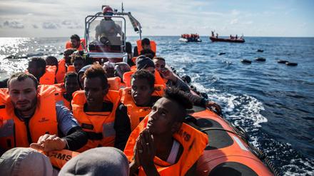 Migranten sitzen in einem Schlauchboot, nachdem eine NGO aus Spanien sie im Mittelmeer gerettet hat.