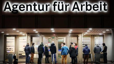 Arbeitssuchende stehen vor der Bundesagentur für Arbeit in Duisburg.