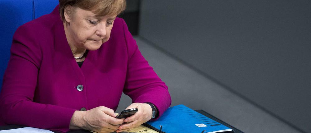 Bundeskanzlerin Angela Merkel mit ihrem Smartphone im Bundestag