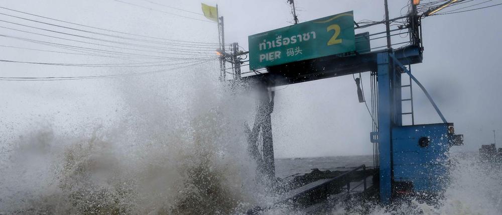Sturmwellen treffen auf ein Pier an der Küste Thailands. 