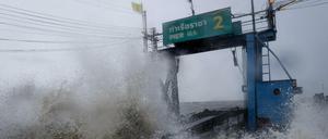 Sturmwellen treffen auf ein Pier an der Küste Thailands. 